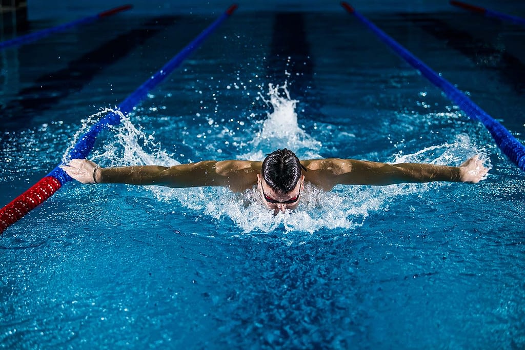a male swimmer does a breaststroke in a swimming pool